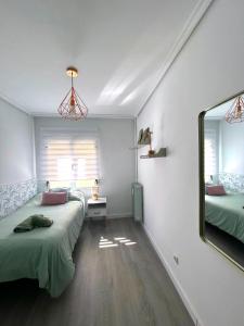 a bedroom with two beds and a mirror at Apartamento LAS ABUBILLAS in Soria +13 photos