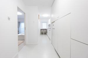 a hallway with white walls and glass doors at Lun Apartment in Cluj-Napoca