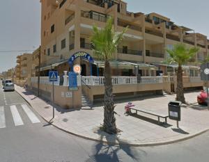 a building with a bench and palm trees in front of it at Vinamar Alena in La Mata