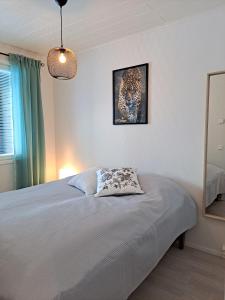 Un dormitorio con una cama con un cuadro en la pared. en Aurinkohiekka A1, en Kalajoki