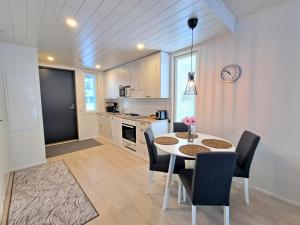 una cocina con mesa y sillas y un reloj en la pared en Aurinkohiekka A1, en Kalajoki 5 fotos más