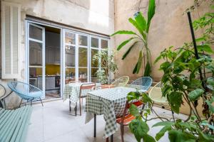 a patio with a table and chairs and plants at Pension Edelweiss Marseille in Marseille