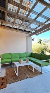 a living room with a green couch and a coffee table at Zamalek Self-catering in Plettenberg Bay