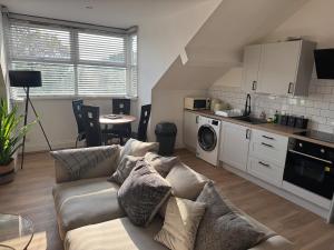 ein Wohnzimmer mit Couch und Küche in der Unterkunft City Centre top floor large flat in Sunderland