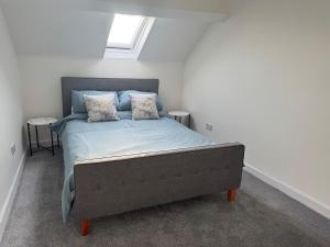 ein Schlafzimmer mit einem Bett mit blauen Laken und einem Fenster in der Unterkunft City Centre top floor large flat in Sunderland