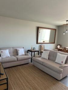 a living room with two couches and a mirror at Póvoa 3 suites in Póvoa de Varzim