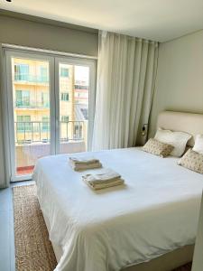 a bedroom with a large bed with towels on it at Póvoa 3 suites in Póvoa de Varzim
