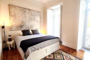 Un dormitorio con una cama con un cuadro en la pared. en Lisbon Design Flat, Luxury, 7 People, Pool Garden, en Lisboa