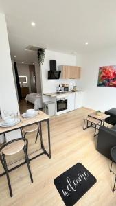 a living room with a table and chairs and a kitchen at Le 63 Stras' - Proche Gare et Centre-Ville Metz in Metz