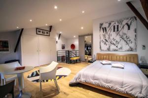 a bedroom with a bed and a table and chairs at Loft 17 in Lisle-sur-Tarn