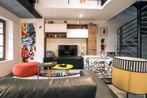a living room with a couch and a table and chairs at Loft 17 in Lisle-sur-Tarn