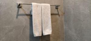 a white towel hanging on a towel rack in a bathroom at Hotel Naman Palace in Varanasi