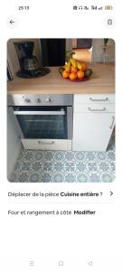 a kitchen counter with a bowl of oranges and a plate of fruit at Appartement le Luxor in Dijon