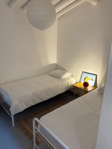 a bedroom with two beds and a table with a picture at Monte da Rocha-Mãe in Barro Branco
