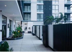 a hallway of a building with a fence and plants at Stylish Apartment with Modern Amenities in Nova Roman Ridge in Accra