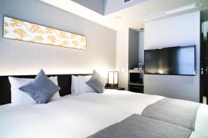 a bedroom with a white bed and a flat screen tv at KIORI Hotel Higashino Toin in Kyoto +71 photos