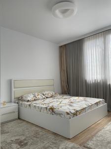 a white bedroom with a bed and a window at City View Prishtina in Pristina