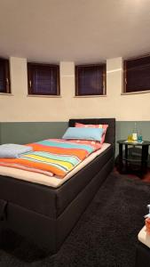 a bed sitting in a room with windows at WiesnNähe Studio - Charmant & zentral mit U-Bahn-Anschluss in Munich