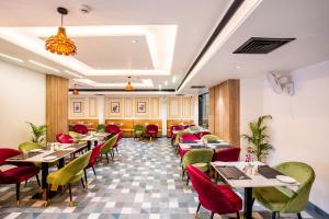 a restaurant with tables and chairs in a room at Regenta Agra in Agra