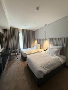 a hotel room with two beds and a desk at ودق للشقق المخدومة in Riyadh