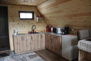 a kitchen with wooden cabinets and a sink and a refrigerator at Green Hill Glamping in Almaty