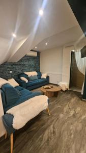 Una sala de estar con un sofá azul y una mesa. en chambre Carla gite le loft bleu, en Sablons