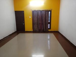 ein leeres Zimmer mit einer Tür und einem Fenster in der Unterkunft Bhedaghat resort in Bherāghāt