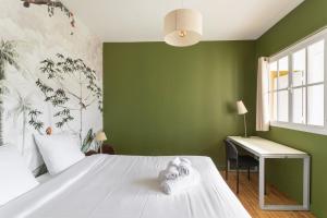 een slaapkamer met groene muren, een bed en een bureau bij Casa Teresa - A proximité de la plage in Pléneuf-Val-André