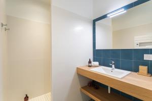 een badkamer met een wastafel en een spiegel bij Casa Teresa - A proximité de la plage in Pléneuf-Val-André