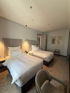 a hotel room with two beds and a chair at ودق للشقق المخدومة in Riyadh