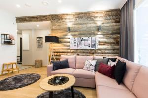 a living room with a pink couch and a wooden wall at Levin Orion Apartments Visit Levi in Levi