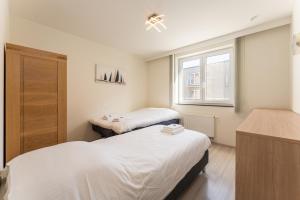 ein Zimmer mit zwei Betten und einem Fenster in der Unterkunft Apartment La Dune Blanche - Ontspannen in Bredene in Bredene