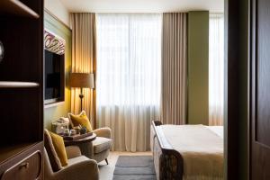 a hotel room with a bed and a chair and a window at Mollie's Manchester in Manchester