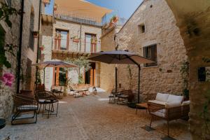 an outdoor patio with tables and chairs and umbrellas at BAGLIO TRAMONTANA in Gangi