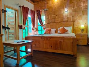 a bedroom with a wooden bed and a table at Serenity Springs Resorts in Muzaffarabad