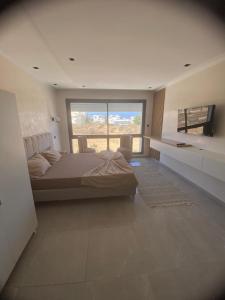 una camera da letto con un letto grande e una grande finestra di Casa del Papel a Akouda