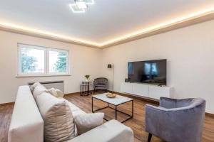 a living room with a couch and a tv at Villa Lio mit Pool in Linardići