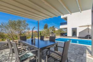 a patio with a table and chairs and a swimming pool at Villa Lio mit Pool in Linardići