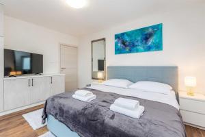 a bedroom with a large bed with two towels at Villa Lio mit Pool in Linardići +40 photos