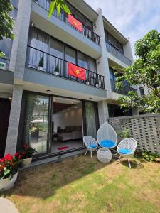 une maison avec trois chaises et un balcon dans l'établissement Ngọc Quyên Villa, à Hiếu Nhơn