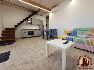 a living room with a table and a couch at Appartamenti La Torre di Cascina in Cascina