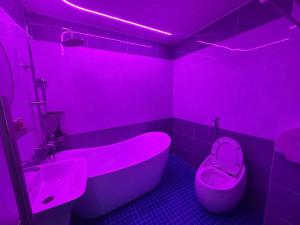 a pink bathroom with a tub and a toilet at Khách Sạn Thu Hà in Ho Chi Minh City