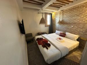 a bedroom with a large white bed with flowers on it at Hotel Islane Médina in Marrakesh