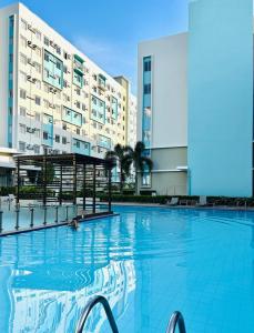 a large swimming pool in front of a building at Studio By The Sea in Dumaguete
