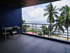 a balcony with a table and a view of the ocean at Anilao Mabini Sea House Diveshop and Resort in Mabini