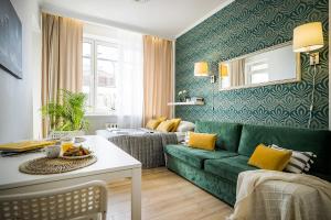 a living room with a green couch and yellow pillows at MGR MiniStudio Bitwy Warszawskiej obok Lotnisko Warszawa in Warsaw
