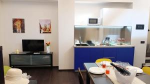 a kitchen with a blue cabinet and a table with chairs at Tema apartment by Ca-Sa Check in Chioggia