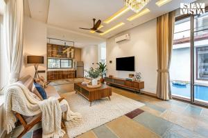 a living room with a couch and a tv at StayVista at Villa Alora with Jacuzzi in Lonavala