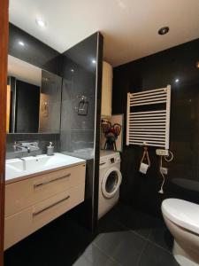 a bathroom with a sink and a washing machine at Pleno centro, 5 minutos Casco Vello, 400 metros estación AVE in Vigo
