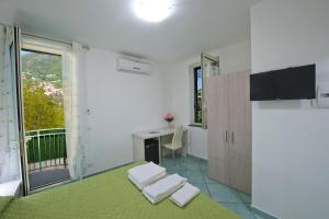 a bedroom with a bed and a desk and a window at Gli Dei gemelli in Agerola